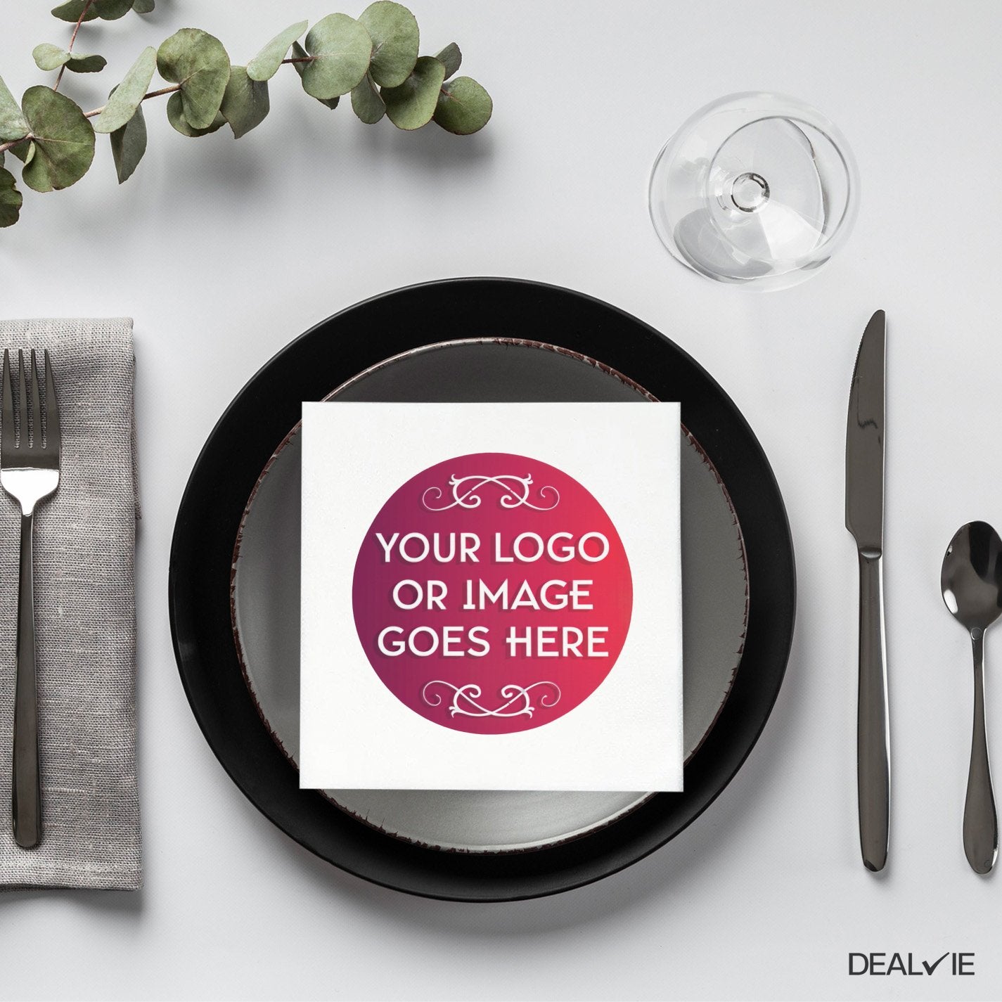 Square napkin with gradient logo on a plate setting.
